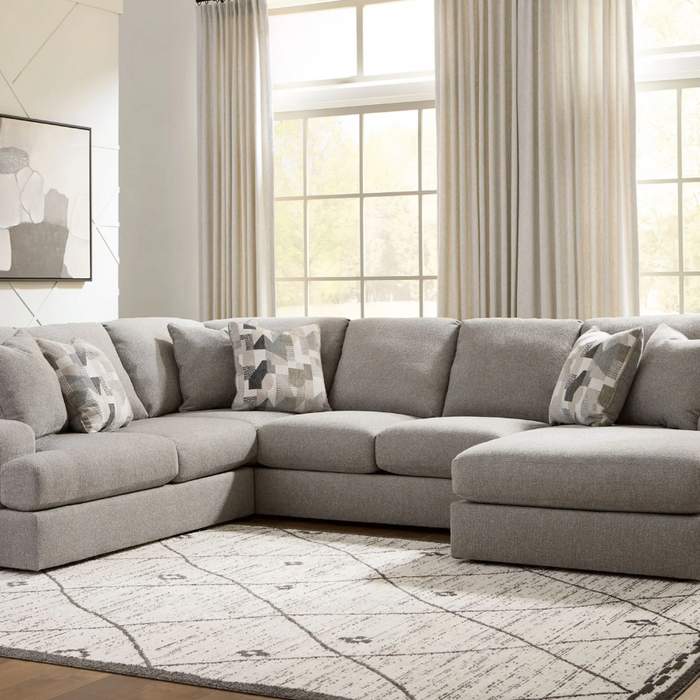 Modern living room sectionals with a comfortable gray fabric, decorative pillows, and large windows letting in natural light.